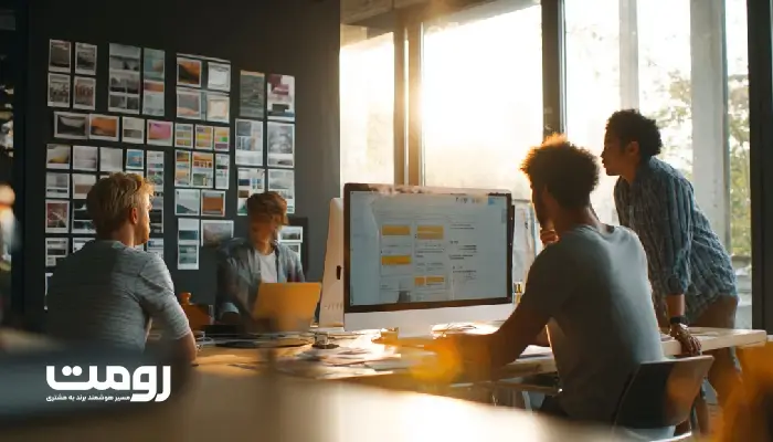 فضای خلاقانه یک آژانس دیجیتال که طراحان در حال بررسی طرحهای اولیه وبسایت و رنگبندی برند هستند.